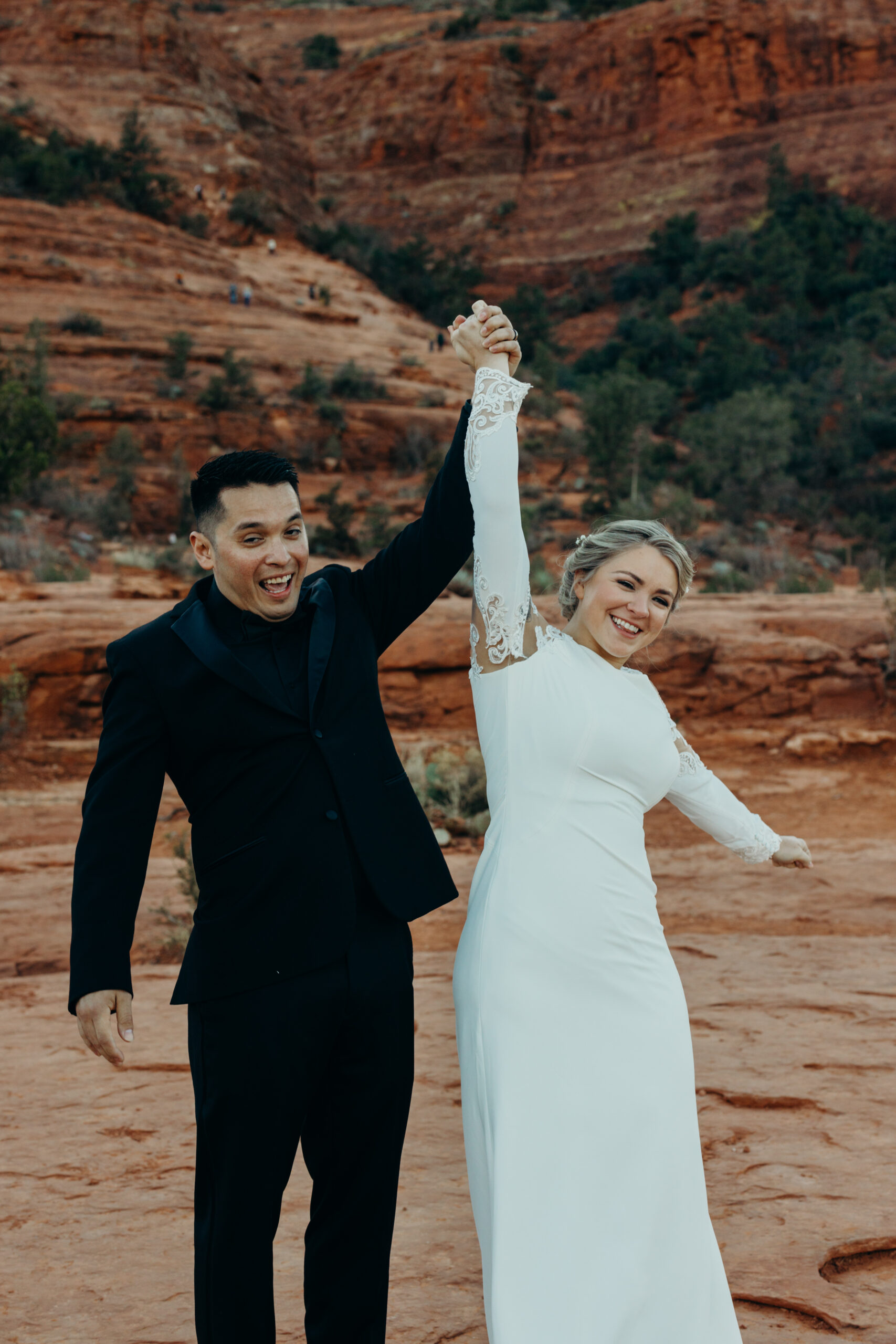 man and woman eloping on the base of cathedral rock cheering